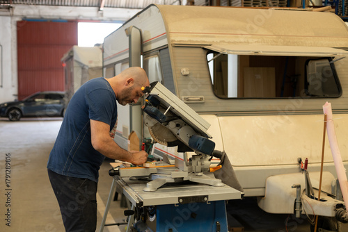 Young man renovating a caravan to convert it into a camper van