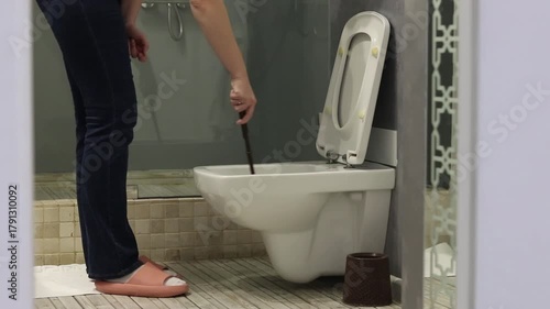 Cleaning the toilet with a brush. Close-up of a woman's hand cleaning the toilet with a brush. Hygiene concept. Checking the cleanliness of the toilet