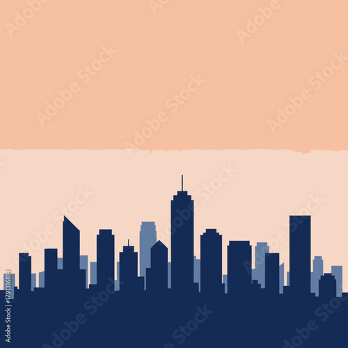 Silhouette of a city skyline against a light orange sky, featuring various building heights and shapes.