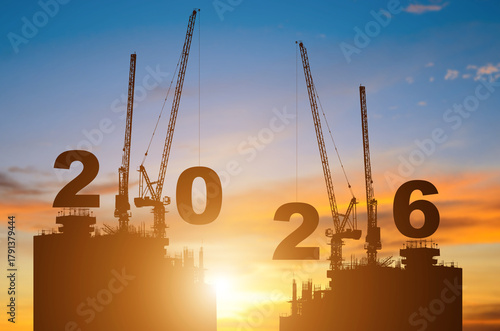 Silhouette of construction camp site with cranes building construction prepare to welcome the new year 2026 at sunset.