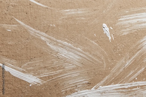 White brush strokes on brown paper create artistic texture