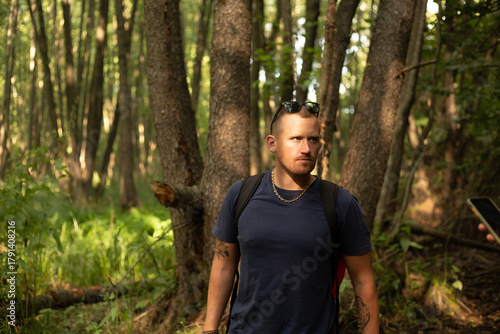 happy young caucasian man walking in the forest