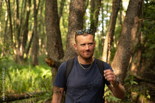 happy young caucasian man walking in the forest