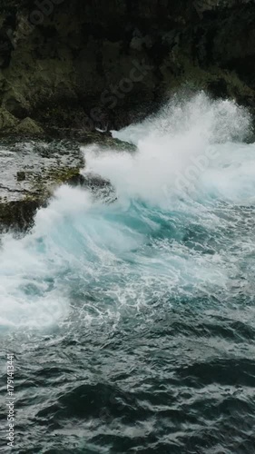 Aerial view of sharp rocky shoreline edge with surf waves and foamy white water. Siargao, Philippines. Slow Motion.
