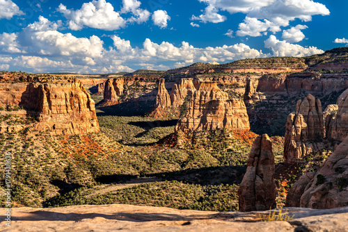 Fototapeta Naklejka Na Ścianę i Meble -  Scenic view of Monument Canyon from Book Cliffs View in Colorado National Monument. Red rock spires, including Independence Monument, fill the canyon under a blue sky