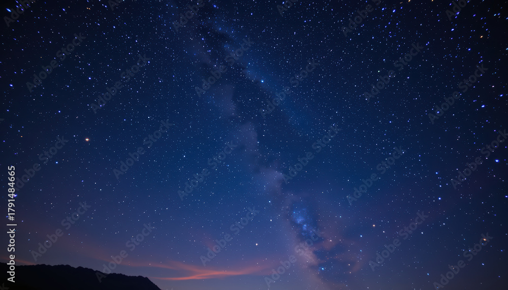 Naklejka premium Stunning view of starry night sky filled with countless stars, showcasing Milky Way galaxy. deep blue hues create serene and tranquil atmosphere, perfect for stargazing and reflection