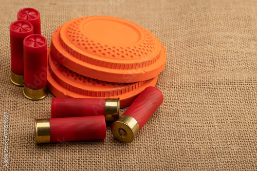 Clay shooting target with shotgun shell on sackcloth background , Clay pigeon shooting game