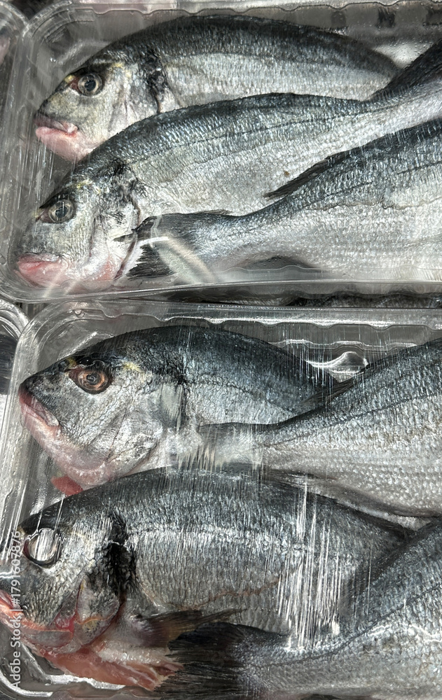 Obraz premium Fresh whole fish packed in clear plastic tray