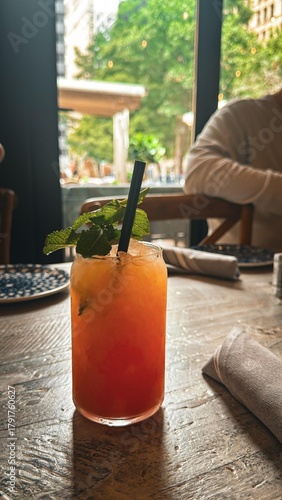 Refreshing iced fruit cocktail with mint served at restaurant table
