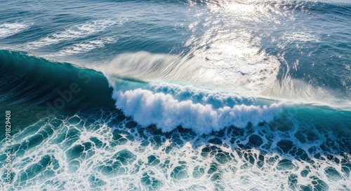 Fototapeta Naklejka Na Ścianę i Meble -  Aerial view of a large ocean wave cresting with bright sunlight reflection.