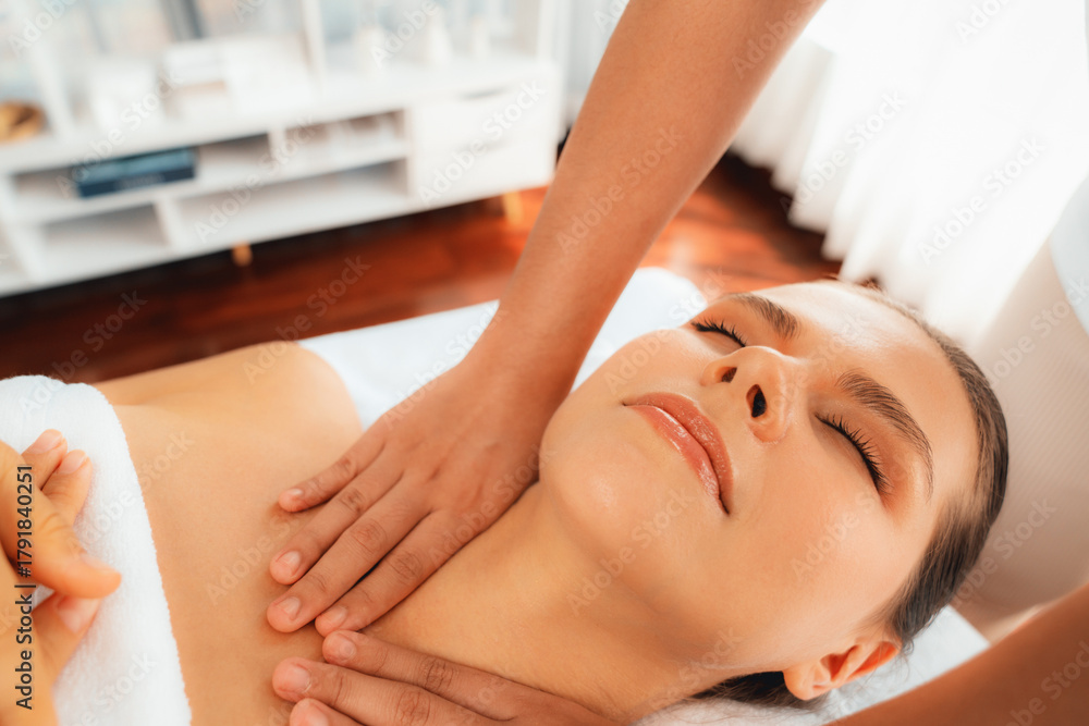 Fototapeta premium Caucasian woman customer enjoying relaxing anti-stress spa massage and pampering with beauty skin recreation leisure in day light ambient salon spa at luxury resort or hotel. Quiescent