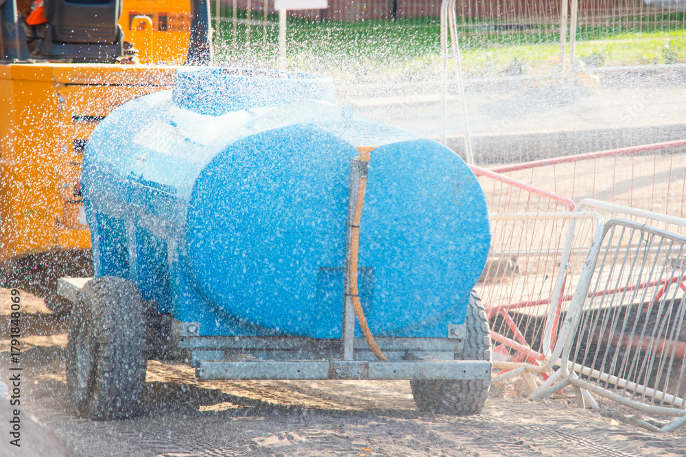 Fototapeta premium Construction site water spraying device used for dust control during hot summer days work