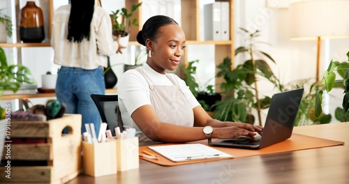 Black woman, plant shop and typing on laptop for small business, inventory or online order. Happy florist, computer and person in office for stock, sales info or floral arrangement in startup nursery