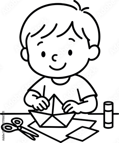 Happy child folds paper boat with scissors and glue