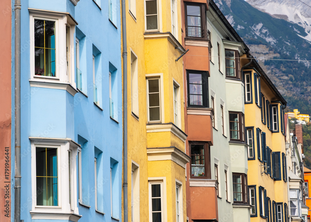 Fototapeta premium Row of colorful historic apartment buildings with glass windows in Innsbruck city, Austria