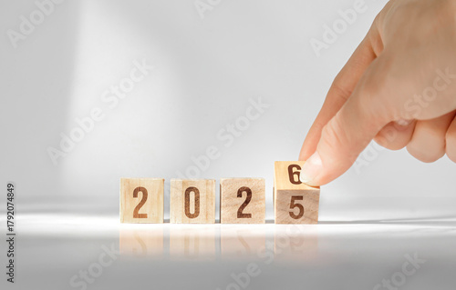 Hand changing wooden cubes from 2025 to 2026 new year concept