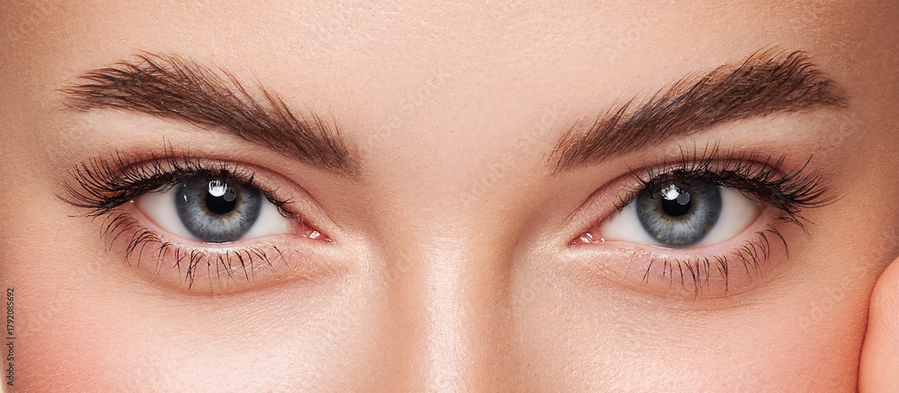 Obraz premium Beautiful female eyes with long eyelashes. Eyelash extensions. Makeup, cosmetics, beauty. Close up, macro