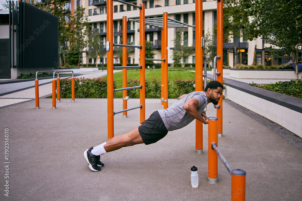 Fototapeta premium Everyday Man Strives To Lose Weight With Outdoor Gym Push-Ups And Calisthenics