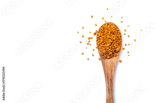 bee pollen grains in wooden spoon isolated on white background. Top view