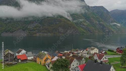 Drone view of the iconic fishing village Undredal set between towering fjord cliffs, Norway