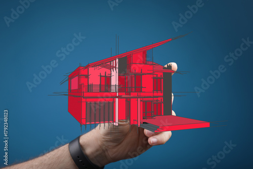 A hand holds a red architec...