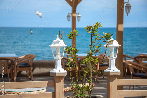 White street lamps enclose the cafe's summer terrace. The restaurant's beautiful design by the seaside.