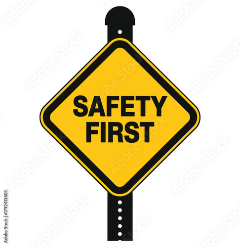 A yellow diamond-shaped sign displays the text 'SAFETY FIRST' in bold black letters, mounted on a black pole.