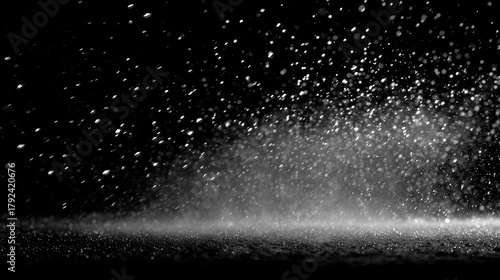 Splashes of water create a misty atmosphere in a dark setting during a rainy day