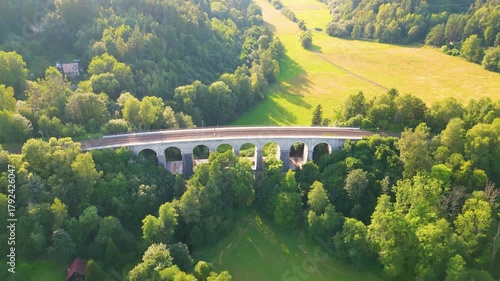 Explore the stunning Sychrov Railway Bridge surrounded by lush greenery in Czech Republic. This iconic structure connects beautiful landscapes while serving rail traffic.