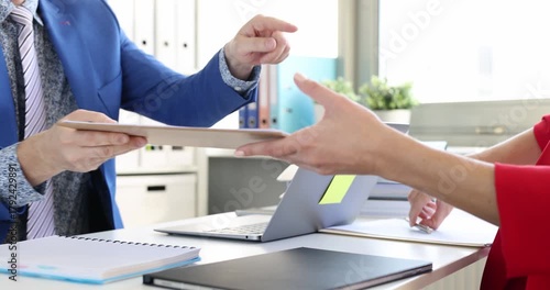 Handshake shows agreement between manager and client near laptop. Colleagues confirm contract before starting project after signing partners document