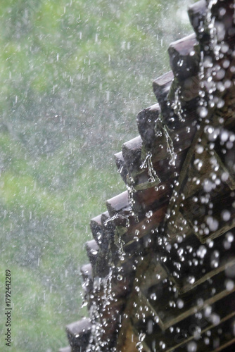Vertical image of heavy rain drops from roof tiles. Rain during the day. Climate and weather concept. For graphic design, banners and 3D rendering