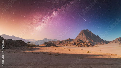 Twilight in desert under dramatic moody sky with stars and a distant mountain. South Sinai, Egypt.