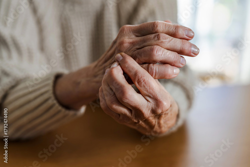 Senior woman with arthritis rubbing hands

