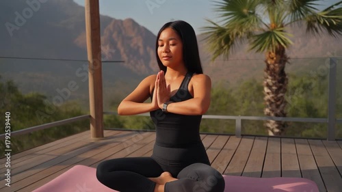Asian Woman Meditating in Yoga Prayer Pose on Outdoor Deck with Mountain View
