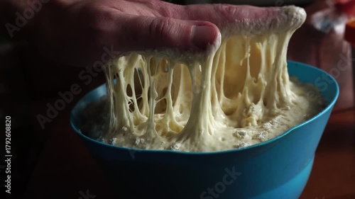 Chef sticks his hand into raw yeast dough. Bread with seeds. Food concept