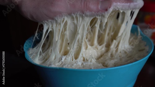 Chef sticks his hand into raw yeast dough. Bread with seeds. Food concept