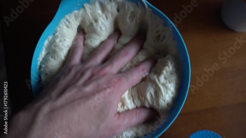 Chef sticks his hand into raw yeast dough. Bread with seeds. Food concept