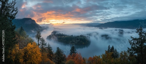 Autumn colors are on full display among the trees surrounding Crown Point's vista house, which stands above the fog-shrouded Columbia River Gorge, in Oregon