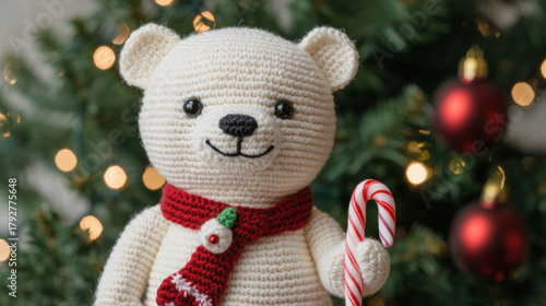 Wallpaper Mural Crochet bear with red scarf holding candy cane in front of christmas tree with festive lights and ornaments, joyful holiday atmosphere Torontodigital.ca