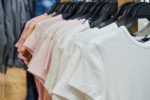 T-shirts on hangers in shop for sale.