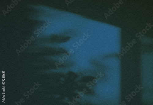 Photography Moody abstract image featuring grainy dark blue tones with a soft, shadowy silhouette and subtle glow, creating a cinematic atmosphere ideal for creative projects and mood visuals