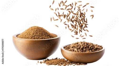 Two wooden bowls filled with cumin seeds and falling cumin seeds isolated on transparent background