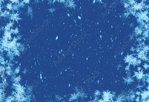Winter blue framed scene with frosted pine branches along the edges and softly falling snowflakes in a deep blue night sky, ideal for holiday designs and seasonal promotions