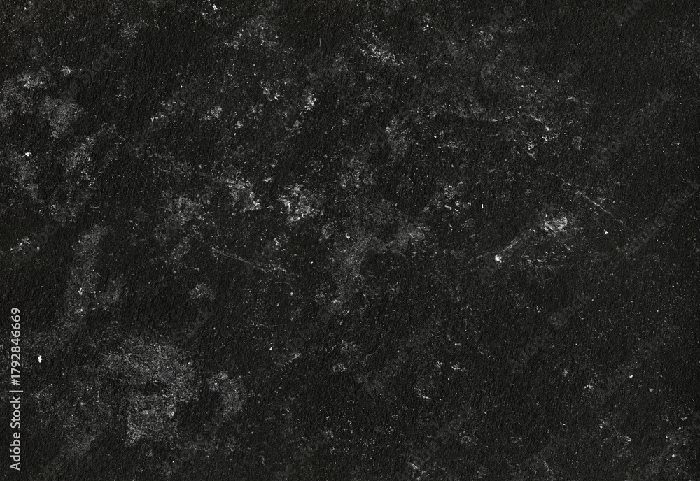 Obraz premium Close up texture of a deep black stone surface with subtle white mineral flecks and a rough granular pattern, ideal for backgrounds, design accents, and product photography