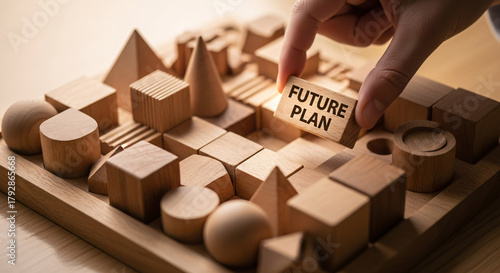 Hand placing future plan block on wooden city model for strategic planning