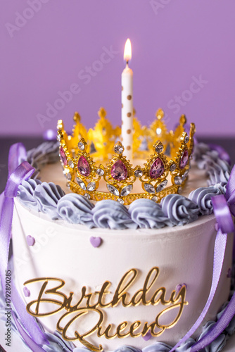 Birthday cake with candle and a crown. Cake with white icing and decor