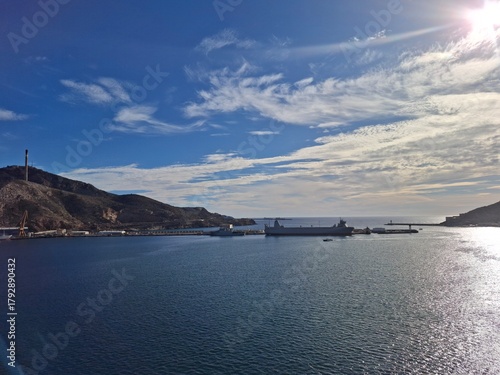 spain marcia jan 4 2024 Harbor View With Docked Ships, Calm Sea And Bright Blue Sky Over Rocky Hills