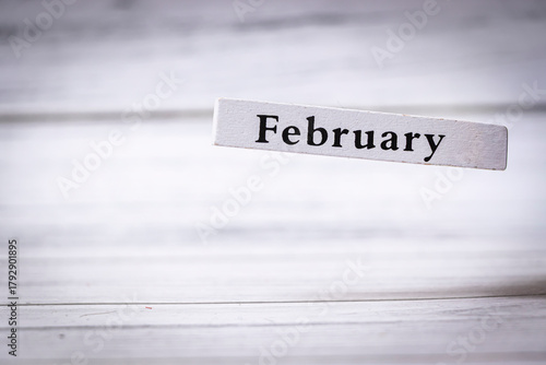 February is displayed on a wooden block on a light background, symbolizing the second month of the year. It represents winter, love, and seasonal change.