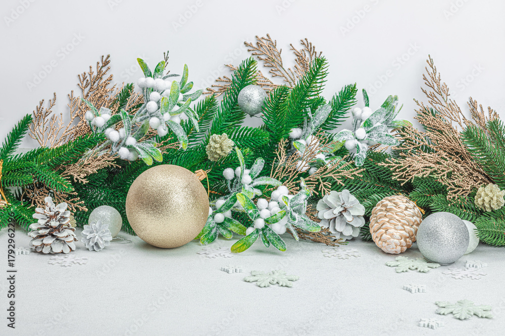 Naklejka premium Traditional New Year composition. Festive decor, snowy Christmas tree branches, balls, flowers