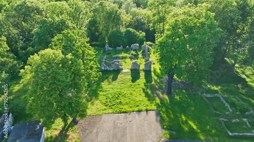 Aerial drone shot of ancient ruins under clear sky, showcasing historic stone structures and scenic surroundings in beautiful daylight.